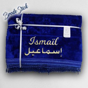 Tapis de prière personnalisé bleu broderie blanche avec prénom en français et arabe superposés.